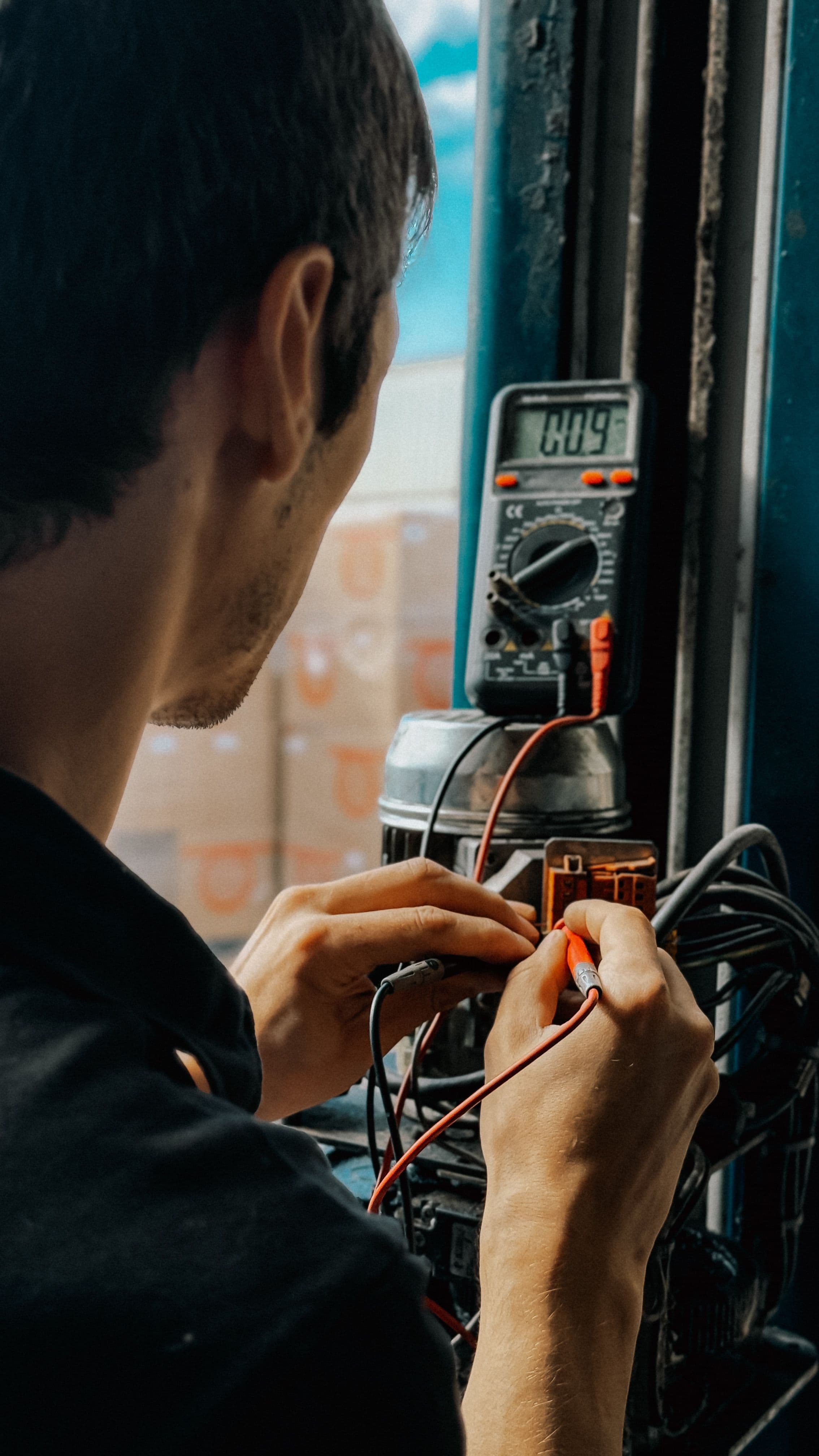 An electrician testing connections inside an electrical panel