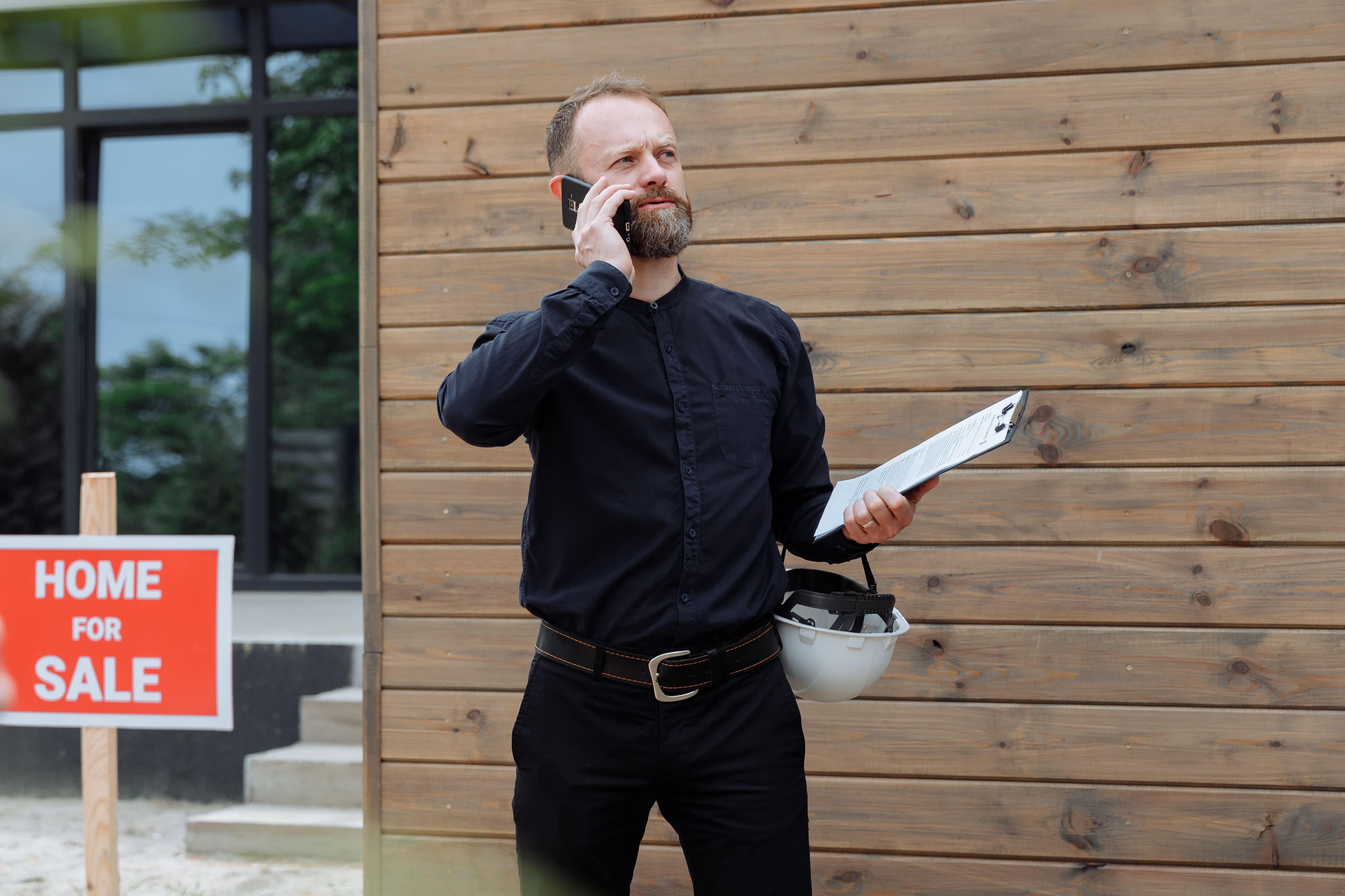 A contractor taking a phone call outside a job site
